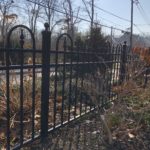arched black aluminum fence on road
