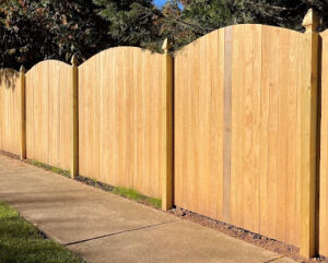wooden fence around sidewalk enclosing pool