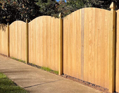 wooden fence around sidewalk enclosing pool
