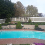beige vinyl fence protecting pool